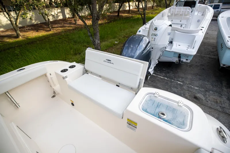 Slide: The Image of 2024 Cobia 220 CC boat interior with seating and engine view. - 10