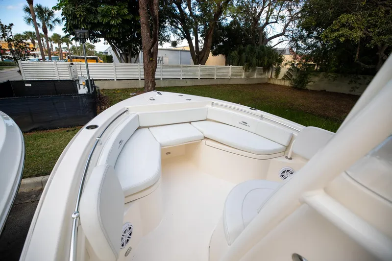 Slide: The Image of 2024 Cobia 220 CC boat interior with white seating and spacious deck. - 21