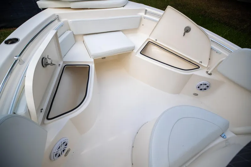 Slide: The Image of 2024 Cobia 220 CC boat interior with open storage compartments and seating. - 26
