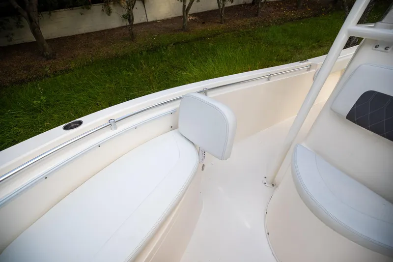 Slide: The Image of 2024 Cobia 220 CC boat interior with white seating and railing. - 27