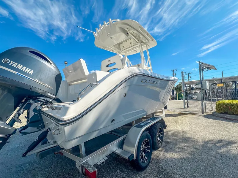 Slide: The Image of 2024 Cobia 220 CC boat on trailer with Yamaha engine under clear blue sky. - 6