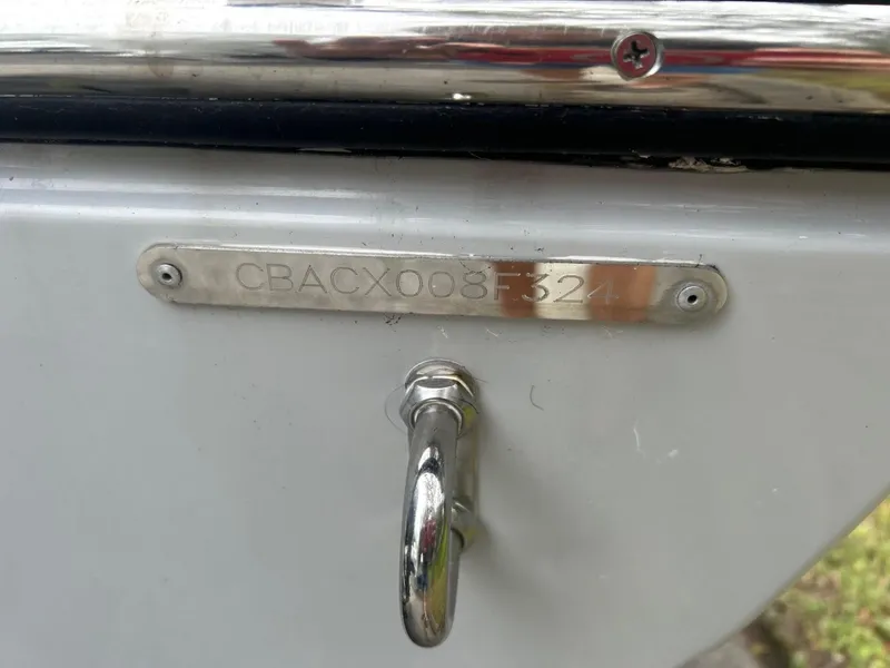 Slide: The Image of 2024 Cobia 220 CC boat hull identification number plate with metal hook. - 29