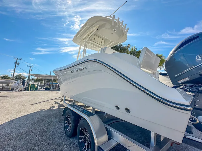 Slide: The Image of 2024 Cobia 220 CC boat on trailer under clear blue sky. - 4