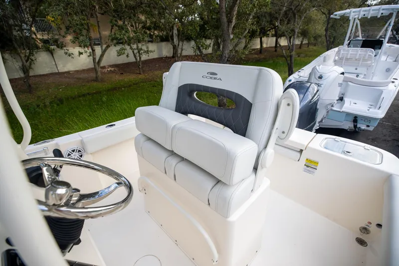 Slide: The Image of 2024 Cobia 220 CC boat interior with steering wheel and seating. - 12
