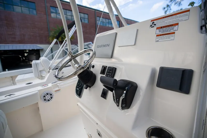 Slide: The Image of 2024 Cobia 220 CC boat console with Garmin navigation system and steering wheel. - 16