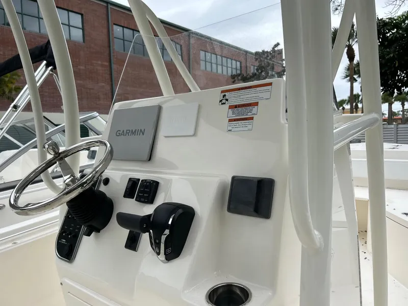 Slide: The Image of 2024 Cobia 220 CC boat console with Garmin navigation system and steering wheel. - 17