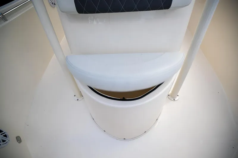 Slide: The Image of 2024 Cobia 220 CC boat seat with storage compartment, white upholstery, and sleek design. - 24