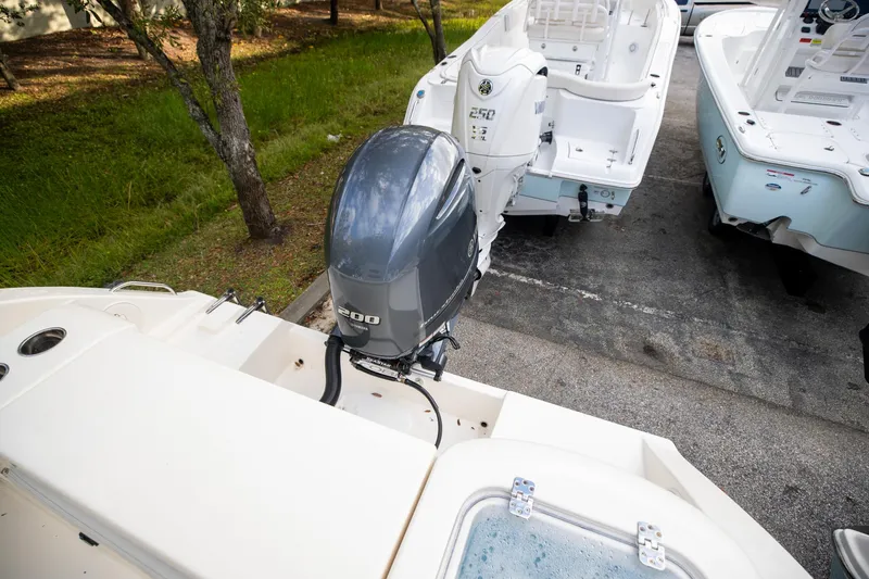 Slide: The Image of 2024 Cobia 220 CC boat with Yamaha 200 outboard motor in a parking area. - 8