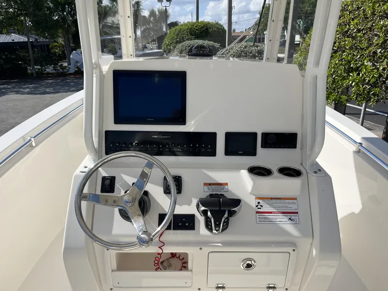 Slide: The Image of 2024 Cobia 262 CC boat dashboard with steering wheel and electronic displays. - 11