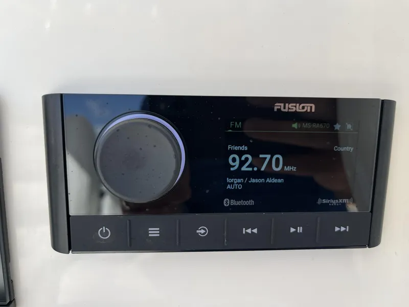 Slide: The Image of Fusion marine stereo display on a 2024 Cobia 262 CC boat dashboard. - 13