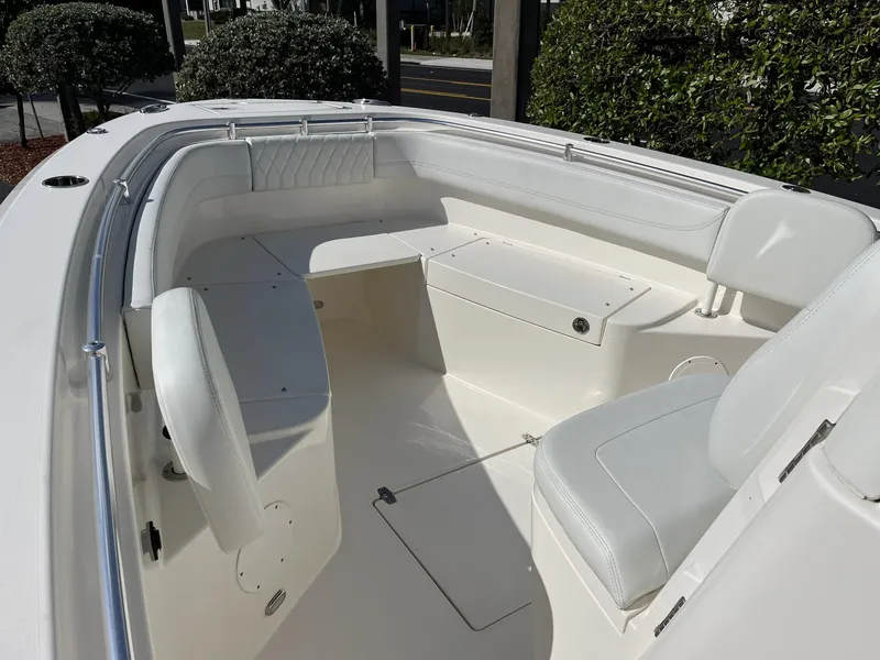 Slide: The Image of 2024 Cobia 262 CC boat interior with white seating and storage compartments. - 16