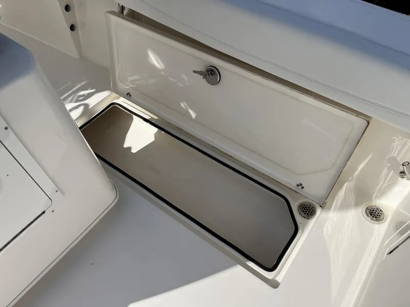 Slide: The Image of 2024 Cobia 262 CC boat storage compartment with open hatch, showcasing interior space. - 30
