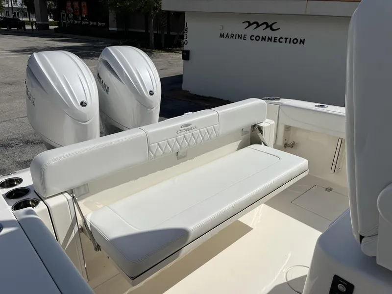 Slide: The Image of 2024 Cobia 262 CC boat with dual Yamaha engines and white seating at Marine Connection. - 31