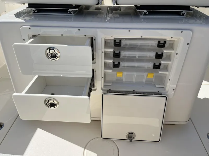 Slide: The Image of 2024 Cobia 262 CC boat storage compartments with drawers and tackle boxes. - 32