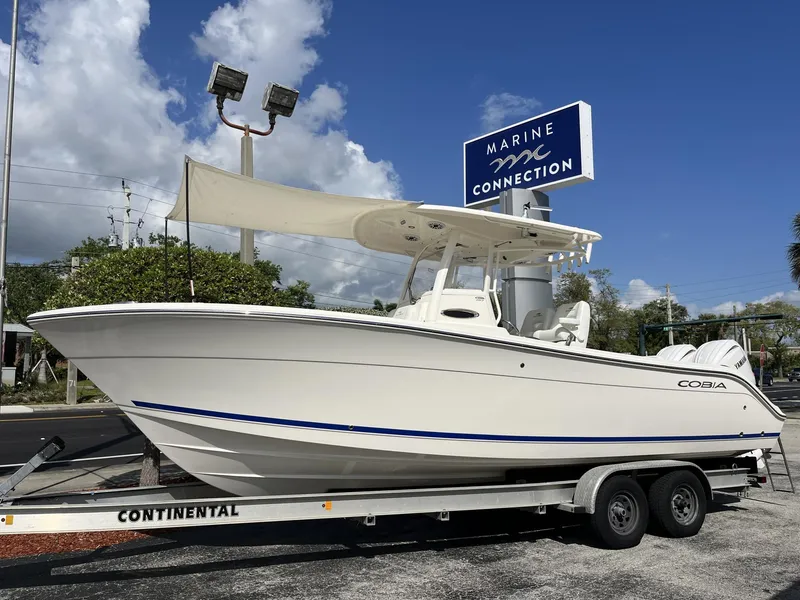 Slide: The Image of 2024 Cobia 262 CC boat on trailer at Marine Connection dealership. - 34