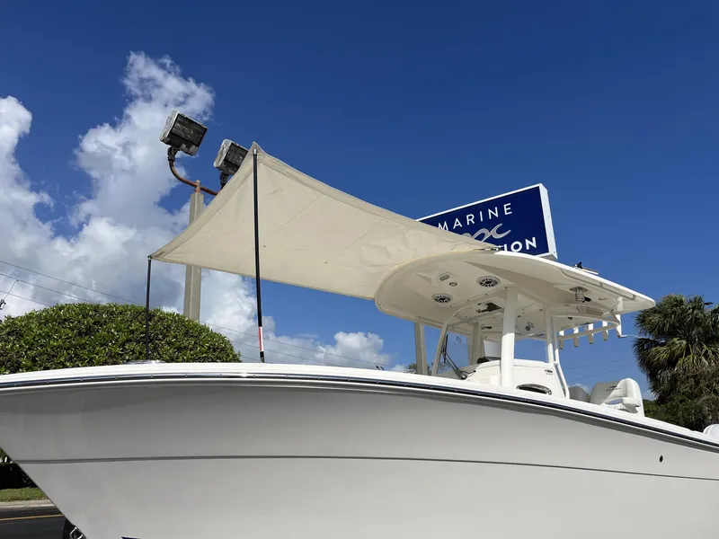 Slide: The Image of 2024 Cobia 262 CC boat with canopy under clear blue sky. - 35