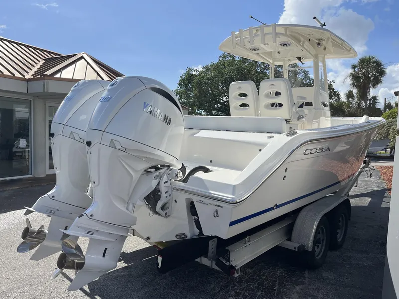 Slide: The Image of 2024 Cobia 262 CC boat with twin Yamaha engines on a trailer. - 6