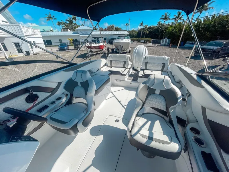 Slide: The Image of 2024 Hurricane SunDeck 2600 OB boat interior with modern seating and steering wheel. - 18