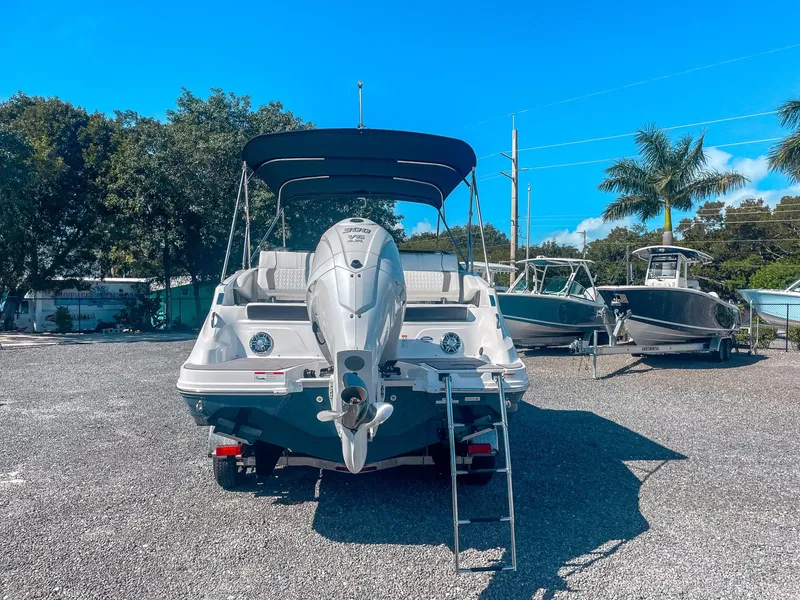 Slide: The Image of 2024 Hurricane SunDeck 2600 OB boat with outboard motor, parked outdoors. - 3