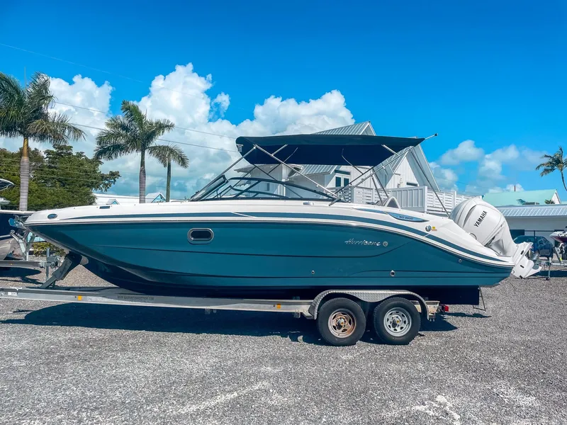 Slide: The Image of 2024 Hurricane SunDeck 2600 OB boat on trailer, sunny day, palm trees in background. - 4