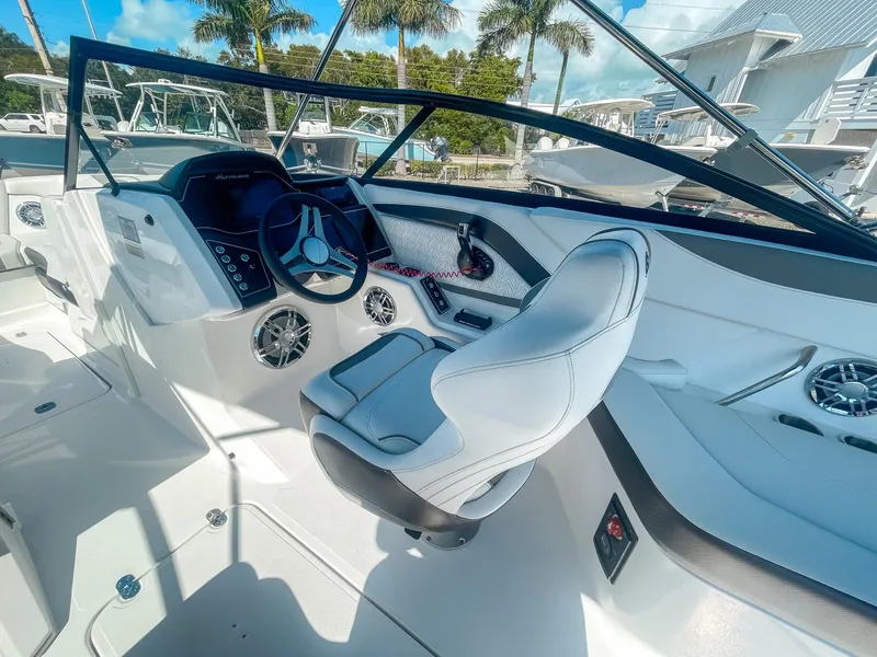 Slide: The Image of 2024 Hurricane SunDeck 2600 OB boat interior with modern steering and seating. - 12