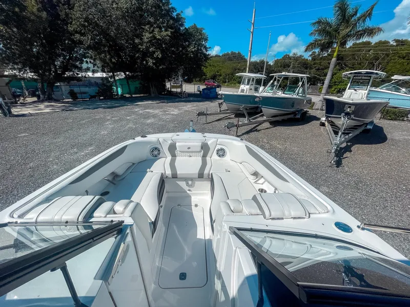 Slide: The Image of 2024 Hurricane SunDeck 2600 OB boat with spacious seating, parked outdoors. - 15