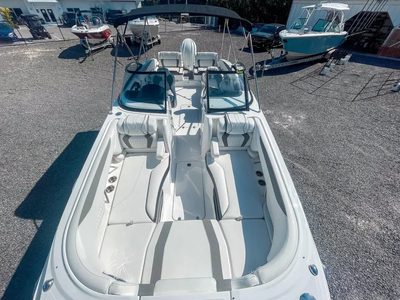 Slide: The Image of 2024 Hurricane SunDeck 2600 OB boat with spacious seating, parked outdoors. - 16