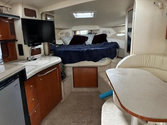 Slide: The Image of Interior of 2000 Sea Ray 340 Sundancer with bed, kitchenette, and dining area. - 15