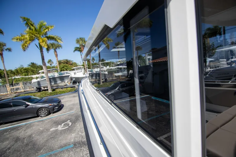 Slide: The Image of 2024 Quarken 35 Cabin boat reflecting palm trees in a sunny parking lot. - 24