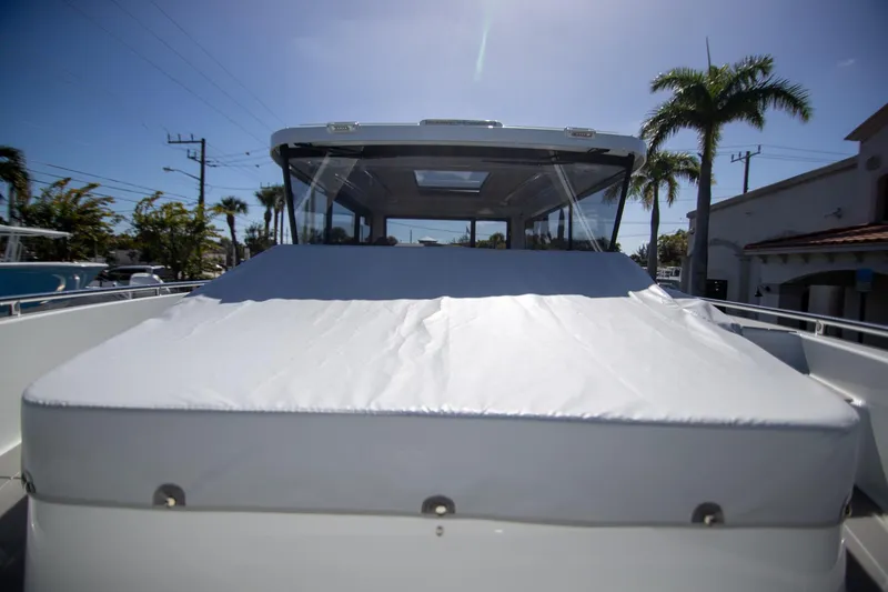 Slide: The Image of 2024 Quarken 35 Cabin boat with covered deck, under clear blue sky and palm trees. - 29