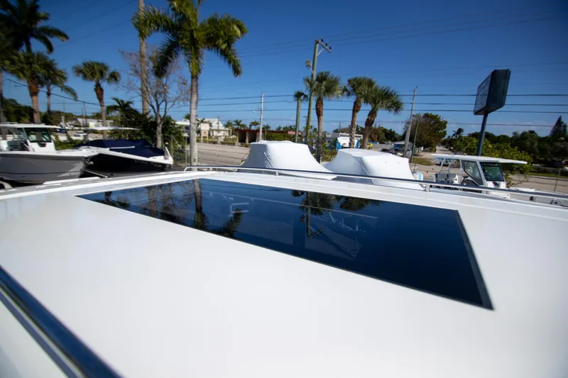 Slide: The Image of 2024 Quarken 35 Cabin boat with sunroof, surrounded by palm trees and clear blue sky. - 31