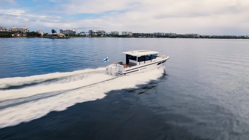 Slide: The Image of 2024 Quarken 35 Cabin boat cruising on calm waters near a coastal city. - 5