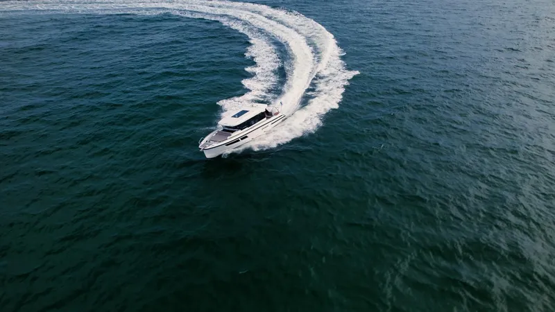 Slide: The Image of 2024 Quarken 35 Cabin boat cruising on open water, creating a dynamic wake. - 4