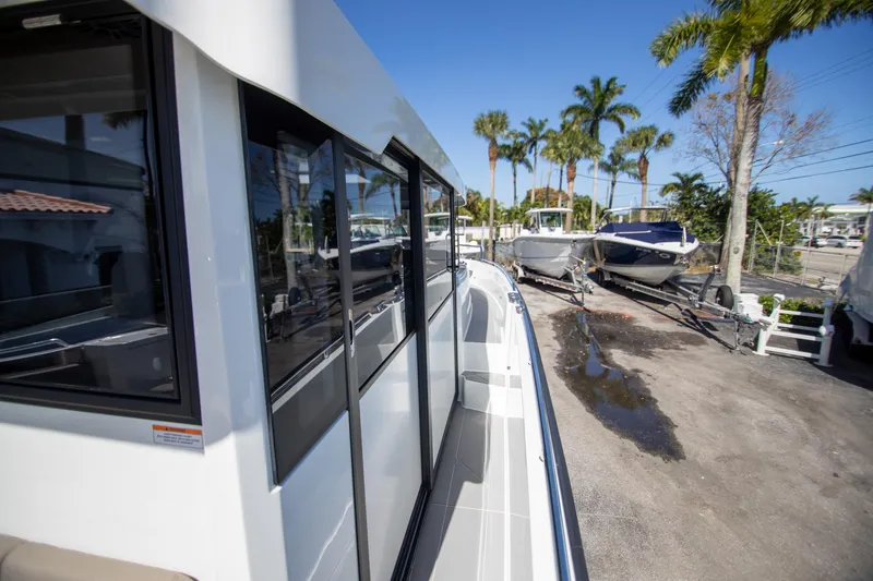 Slide: The Image of 2024 Quarken 35 Cabin boat exterior with palm trees in the background. - 25