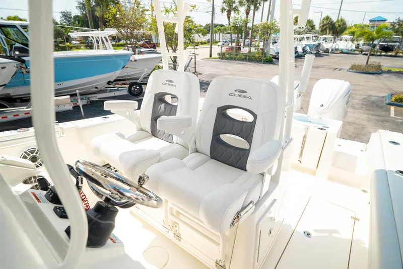 Slide: The Image of 2024 Cobia 301 CC boat interior with plush seating and modern steering wheel. - 20