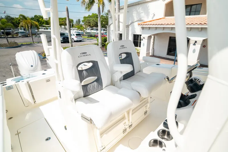 Slide: The Image of 2024 Cobia 301 CC boat interior with dual white captain's chairs. - 21