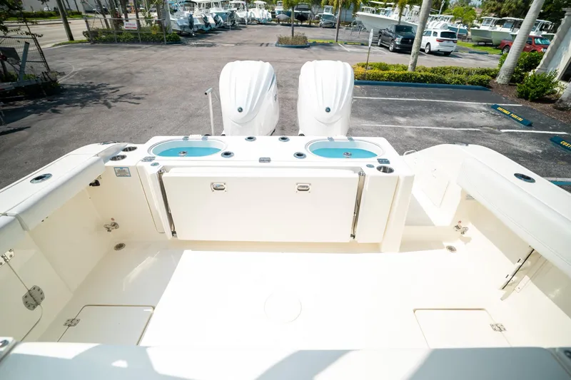 Slide: The Image of 2024 Cobia 301 CC boat deck with dual engines and spacious seating area. - 22