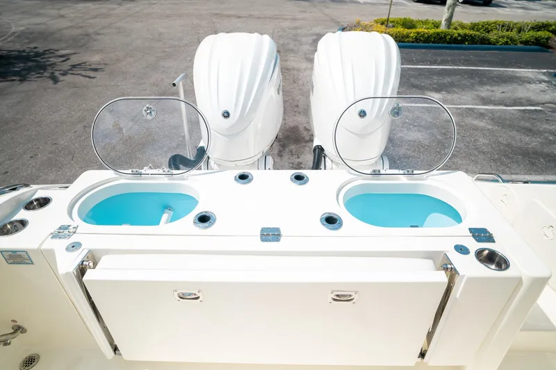 Slide: The Image of 2024 Cobia 301 CC boat with dual outboard engines and open livewells. - 25