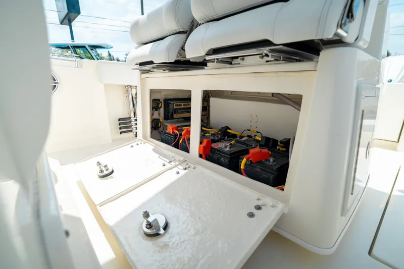 Slide: The Image of 2024 Cobia 301 CC boat battery compartment with wiring and storage. - 36