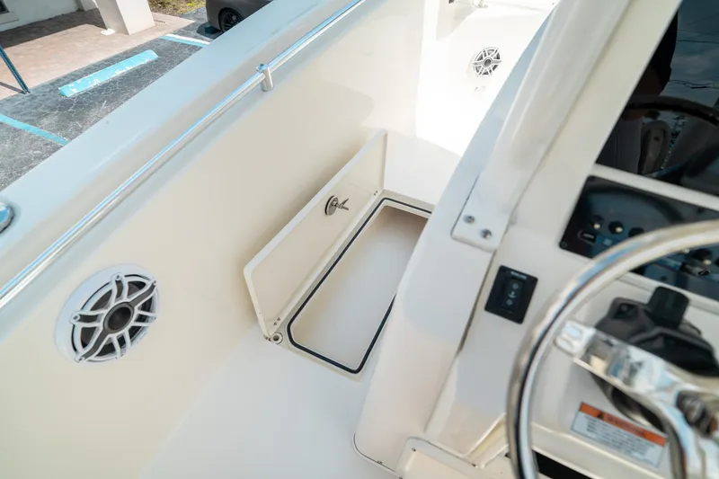 Slide: The Image of 2024 Cobia 301 CC boat interior with storage compartment and speaker. - 38