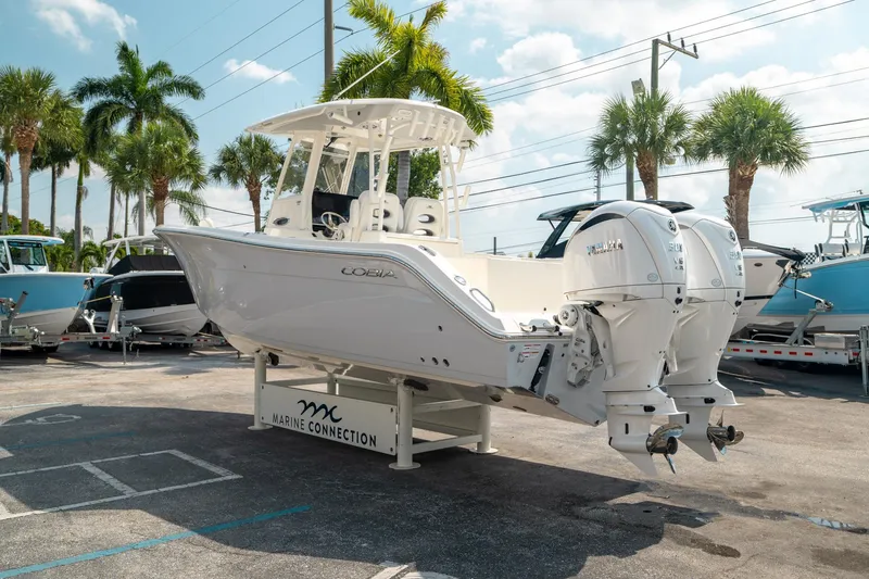 Slide: The Image of 2024 Cobia 301 CC boat with dual engines displayed at Marine Connection dealership. - 4