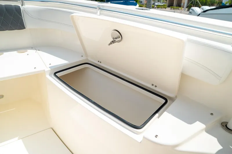 Slide: The Image of 2024 Cobia 301 CC boat storage compartment open, showcasing interior space. - 45