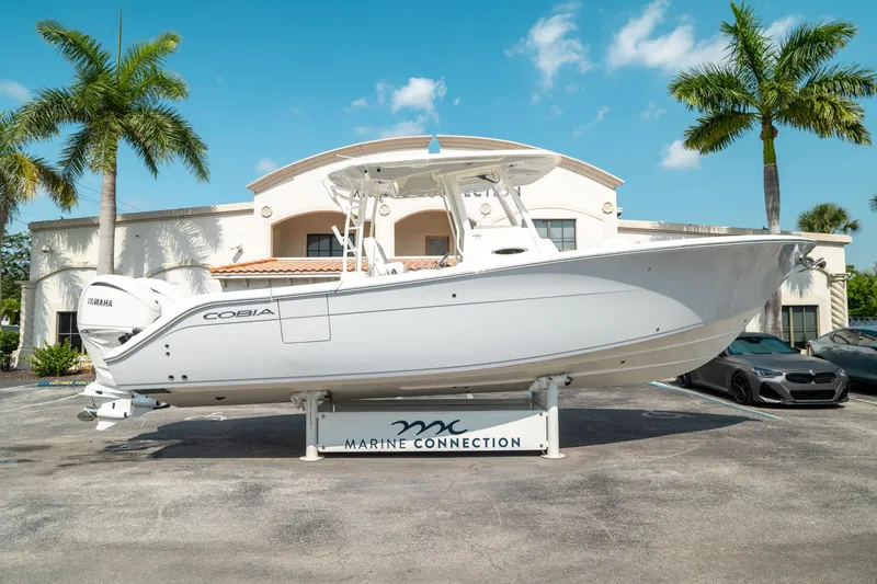 Slide: The Image of 2024 Cobia 301 CC boat displayed at Marine Connection dealership. - 1