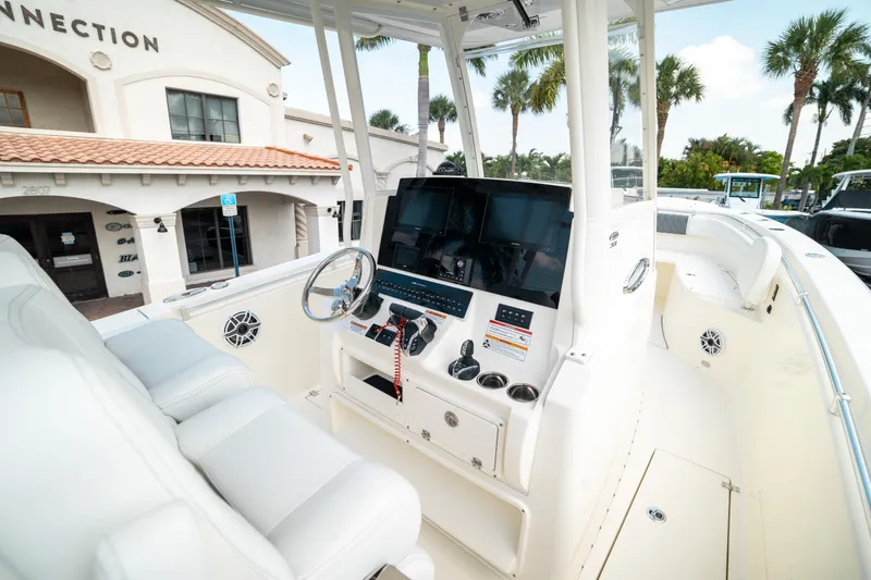 Slide: The Image of 2024 Cobia 301 CC boat interior with modern dashboard and seating. - 10