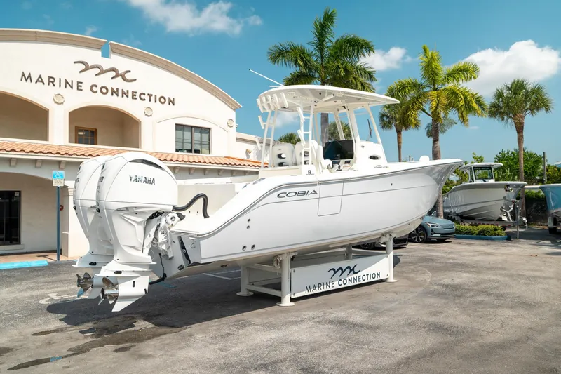 Slide: The Image of 2024 Cobia 301 CC boat displayed at Marine Connection dealership. - 2