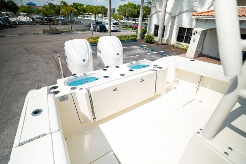 Slide: The Image of 2024 Cobia 301 CC boat with dual engines, spacious deck, and modern design. - 24