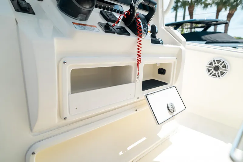 Slide: The Image of 2024 Cobia 301 CC boat console with storage compartments and speaker. - 35