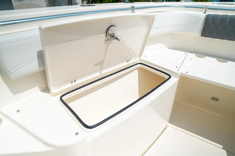 Slide: The Image of Open storage compartment on 2024 Cobia 301 CC boat deck. - 44