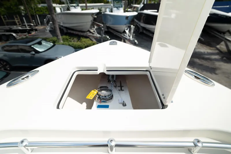 Slide: The Image of 2024 Cobia 301 CC boat with open storage compartment on deck. - 46