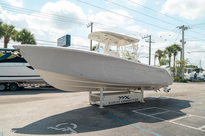 Slide: The Image of 2024 Cobia 301 CC boat displayed at Marine Connection dealership. - 6